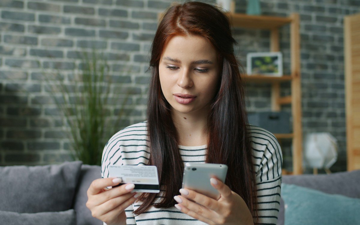 Customer shopping online with a smartphone and payment card